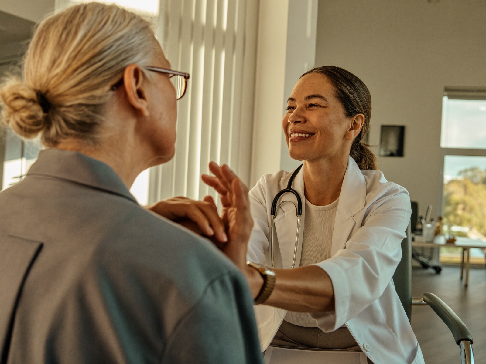 A GP consulting with a patient in a sunlit clinic